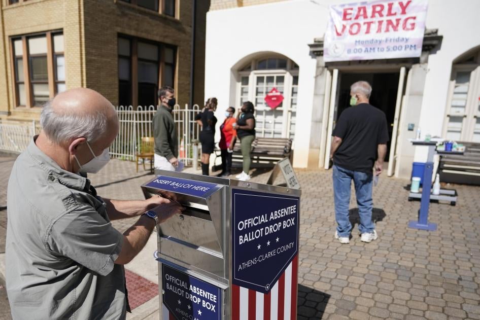 A voter drops their ballot off during early voting, October 19, 2020, in Athens, Georgia. 
