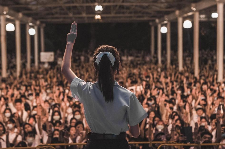 A high school student holds up the three-finger salute and gives a speech at a youth-led rally in Chiang Mai, Thailand on August 25, 2020. © 2020 Supitcha Chailom