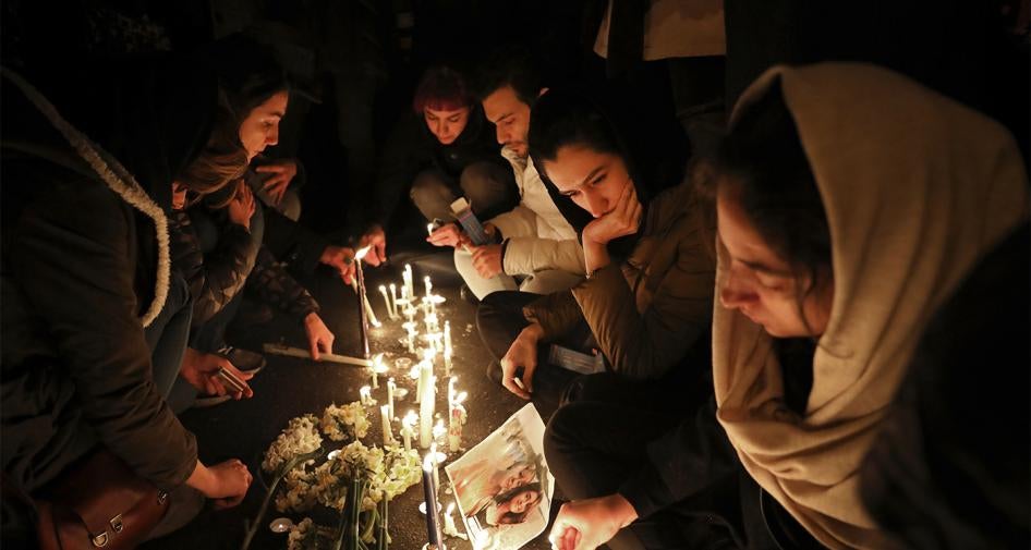 أشخاص يتجمعون لإضاءة شموع إحياء لذكرى ضحايا تحطم الطائرة الأوكرانية عند مدخل جامعة "أمير كبير" التي كان بعض الضحايا من طلابها السابقين، في 11 يناير/كانون الثاني 2020، طهران، إيران.