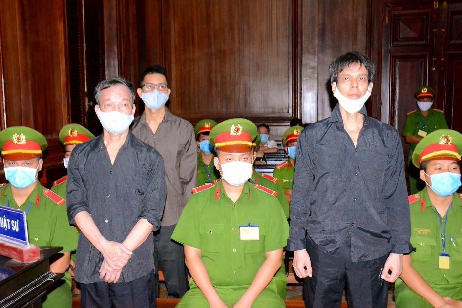 Hình do Thông tấn xã Việt Nam công bố vào ngày mồng 5 tháng Giêng năm 2021: ba blogger người Việt là Phạm Chí Dũng (bên phải), Nguyễn Tường Thụy (bên trái, trước) và Lê Hữu Minh Tuấn (bên trái, sau) trong phiên tòa xét xử họ ở Thành phố Hồ Chí Minh.