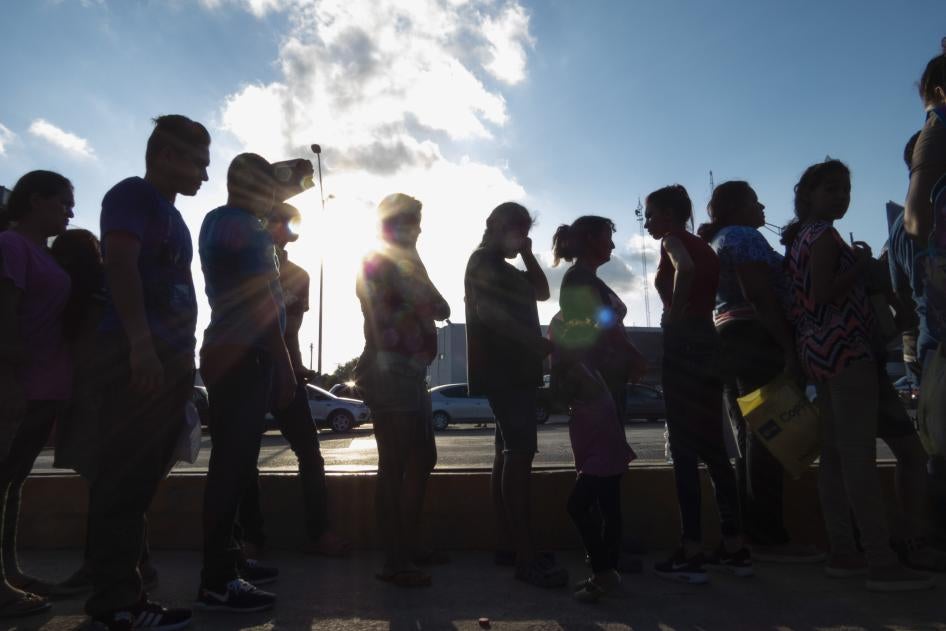Migrants seeking asylum wait in line with their case paperwork to meet with an attorney on Oct. 5, 2019, during a weekly trip by volunteers, lawyers, paralegals and interpreters to the migrant campsite outside El Puente Nuevo in Matamoros, Mexico.