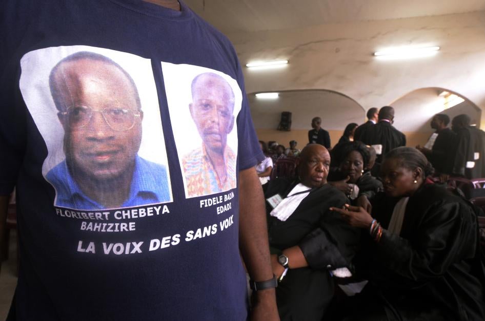 A man wearing a T-shirt with portraits of Floribert Chebeya and Fidèle Bazana attends the trial in Kinshasa on April 30, 2013 of policemen accused of killing the two men in 2010.
