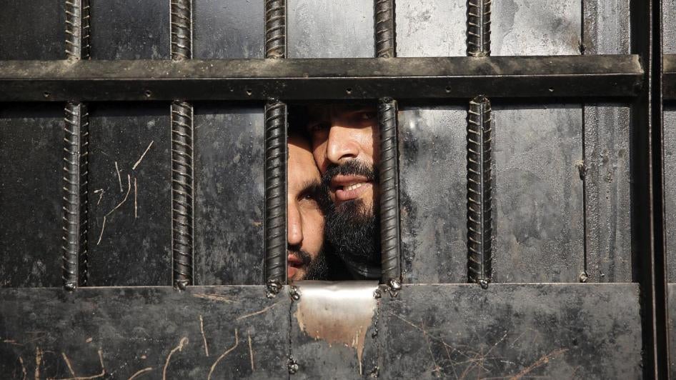 Taliban prisoners look out a prison door in the city of Jalalabad, August 3, 2020.