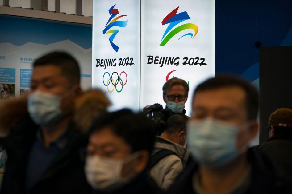 Attendees wearing face masks look at an exhibit at a visitors center at the Winter Olympic venues in Yanqing on the outskirts of Beijing, February 5, 2021.