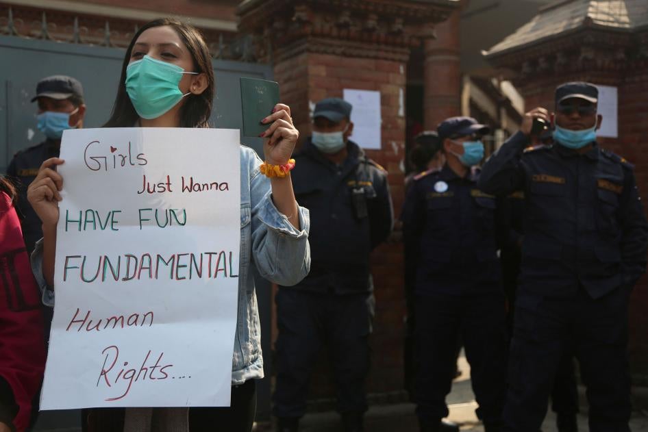 A Nepalese woman holds a placard against a proposed rule which restricts foreign travel for women under 40 years during a protest outside the Department of Immigration in Kathmandu, Nepal, February 11, 2021.