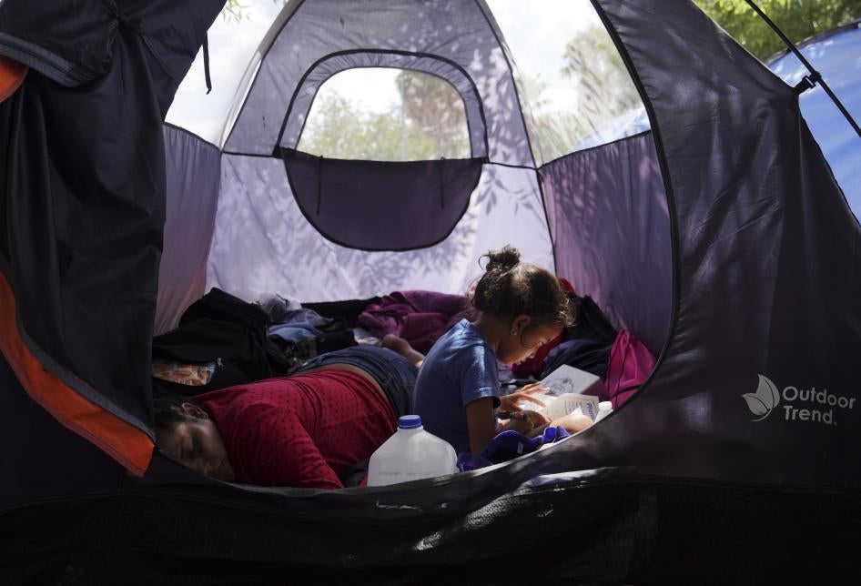 Asylum seeker Yareni, age five, flips through the pages of a book in an encampment where she lives near the Gateway International Bridge in Matamoros, Mexico. 