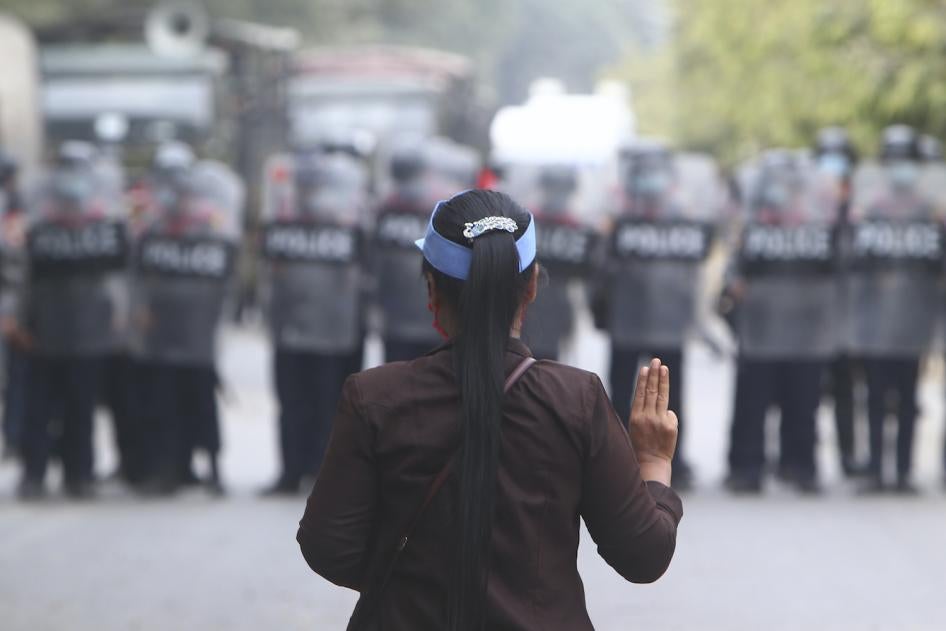 Une manifestante face à une rangée de policiers anti-émeute à Mandalay, au Myanmar, faisait le salut à trois doigts symbolisant le mouvement pro-démocratie, le 20 février 2021.
