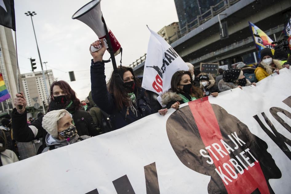 Protesters hold a banner of Strajk Kobiet (Women's Strike) during a protest in Warsaw on March 8,  International Women's Day, organized by the Women's Strike (Strajk Kobiet) against the ruling Law and Justice (PiS) party and the decision of the Constitutional Court.
