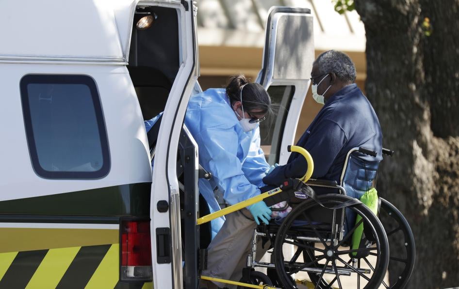 Une travailleuse de la santé ajuste le fauteuil roulant d’un résident du centre «Southeast Nursing and Rehabilitation Center» à San Antonio (Texas), afin de faciliter son entrée dans une ambulance, le 1er avril 2020.