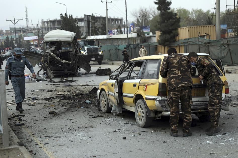 Security personnel inspect the site of a bomb attack in Kabul, Afghanistan on Monday, March 15, 2021. 