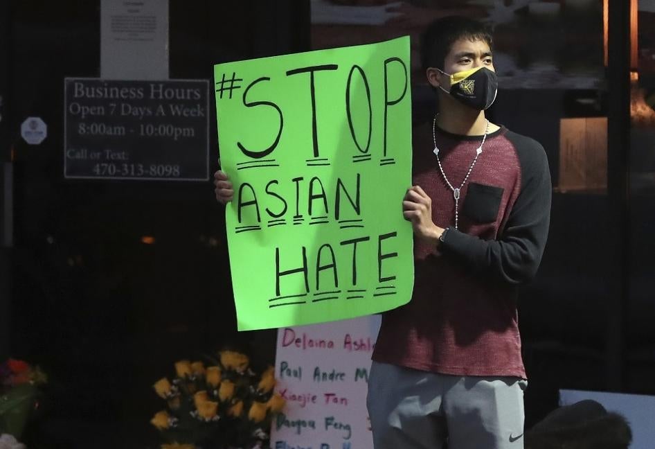 A man holds a sign reading “#StopAsianHate” outside Youngs Asian Massage in Acworth, Georgia on March 17, 2021, where four people were fatally shot the day before. 