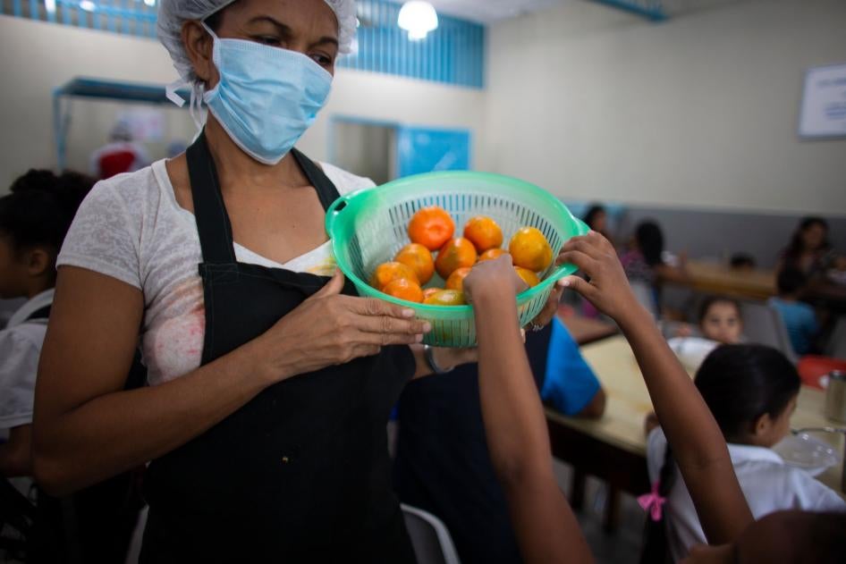 Una niña agarra una mandarina en un comedor en Petare, Venezuela, el 27 de febrero de 2020.