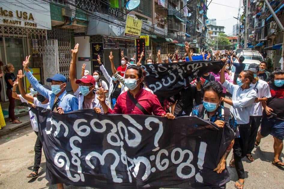 Anti-coup protesters hold a banner that reads "What are these? We are Yangon residents!" as they march during a demonstration in Yangon, Myanmar on Tuesday April 27, 2021.