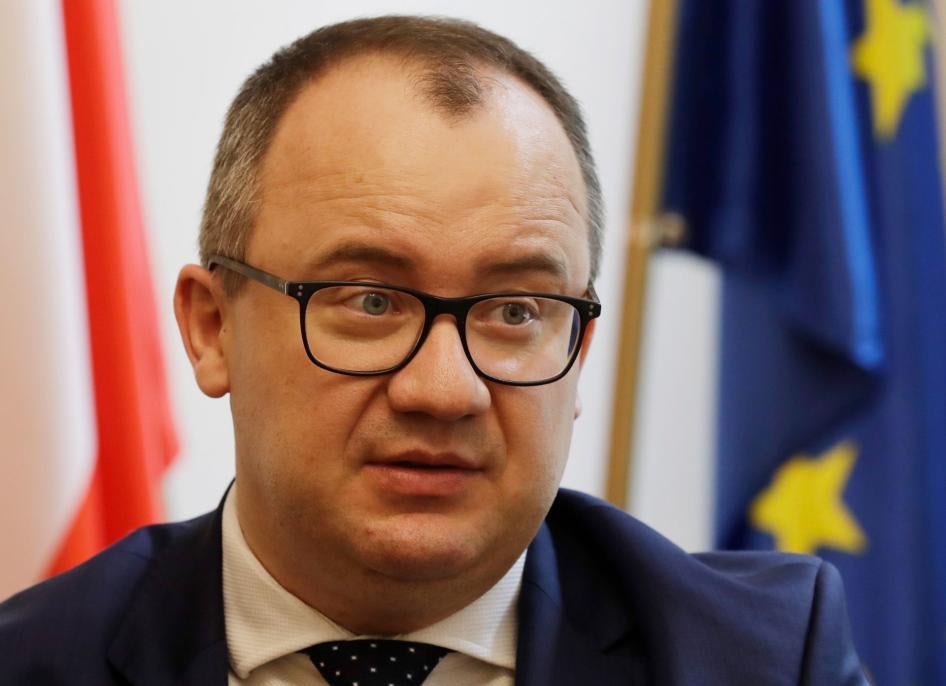 Adam Bodnar, the outgoing Human Rights Commission for Poland, speaks to The Associated Press from his office in Warsaw, Poland, standing in front of the Polish and EU flags.