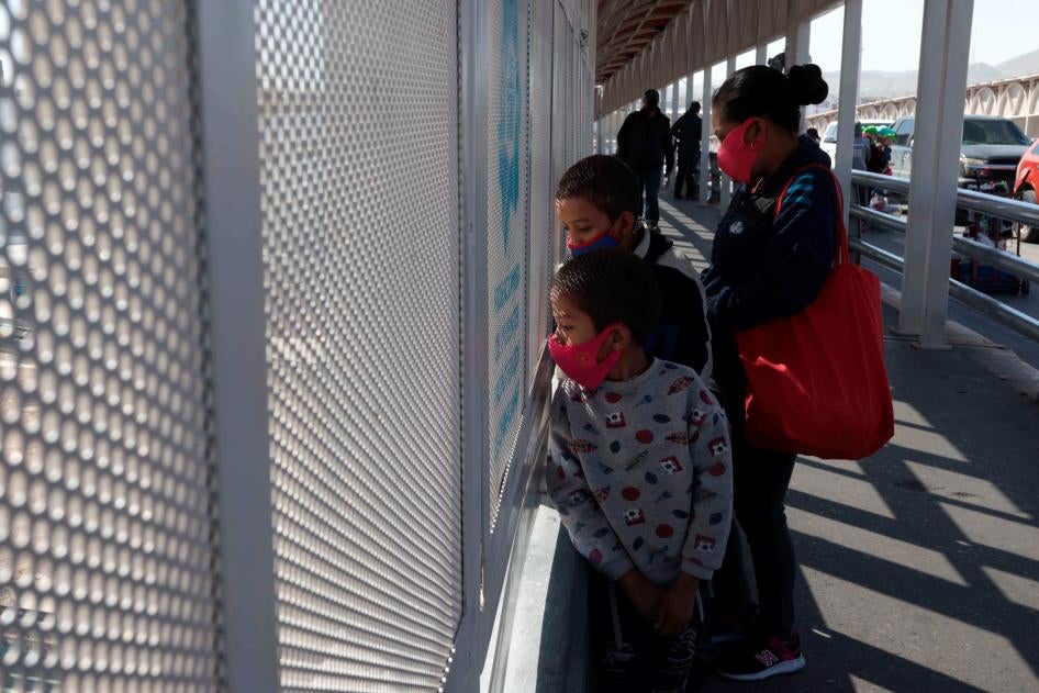 An asylum seeking family from Guatemala stands on the Paso del Norte international bridge. After border agents turned the family away at the port of entry, the family swam across the Rio Grande.