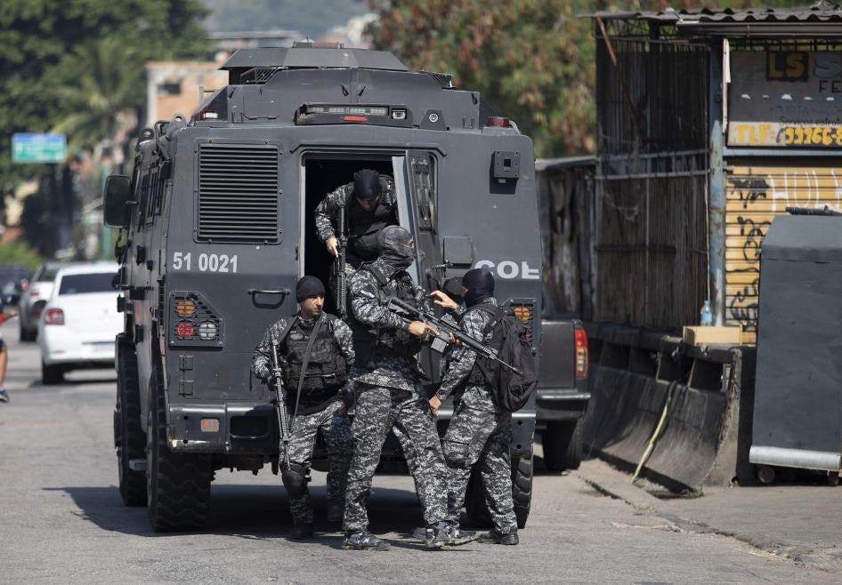 Policiais fortemente armados saem de um veículo blindado durante uma operação em 6 de maio de 2021 na comunidade Jacarezinho, no Rio de Janeiro, Brasil.