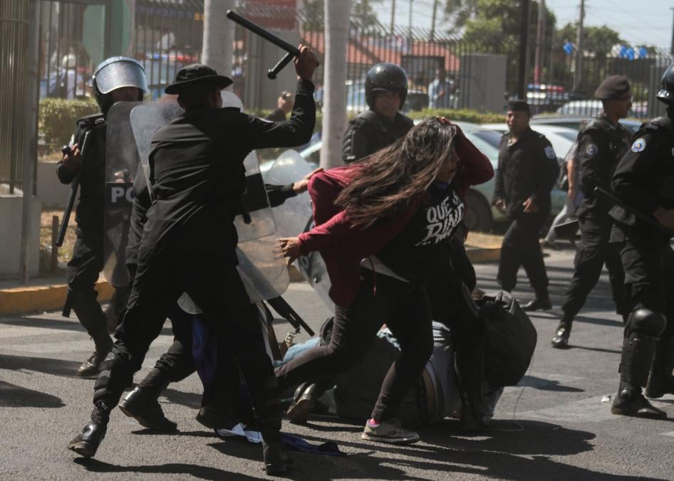 National police officers beat opposition member Valeska Valle and other demonstrators taking part in a "National sit-in" protest against President Daniel Ortega's government in Managua on March 30, 2019.