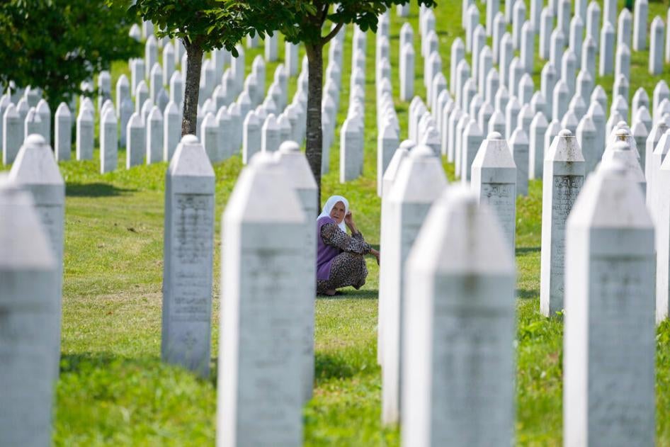 A woman among the graves of victims of the Srebrenica genocide, at the memorial cemetery in Potocari, near Srebrenica, Tuesday, June 8, 2021.