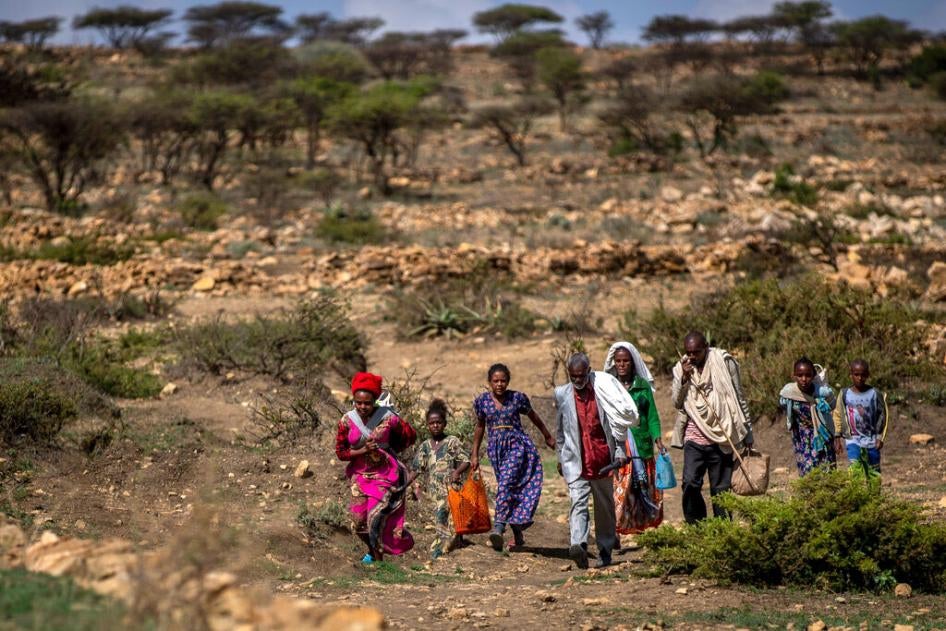People walk from a rural area towards a food distribution site near the town of Agula, in Tigray, Ethiopia