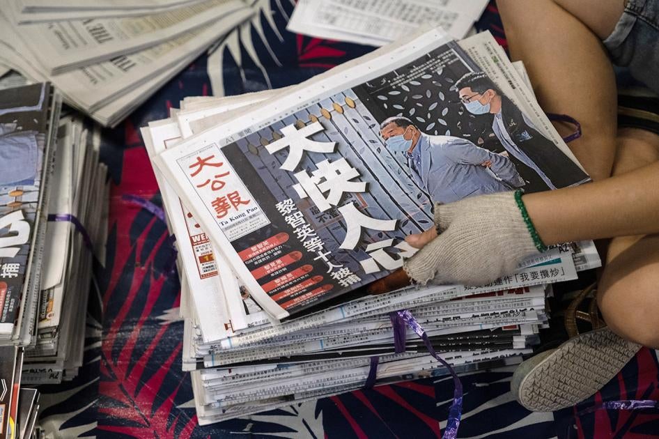 A vendor handles a copy of the Ta Kung Pao newspaper on August. 11, 2020. The day before, Hong Kong police arrested Next Digital Ltd. Chairman Jimmy Lai and several of his top executives for allegedly violating the National Security Law, and sent hundreds of officers to search the Apple Daily newspaper's offices. The Ta Kung Pao front headline reads, "Very Happy!" 