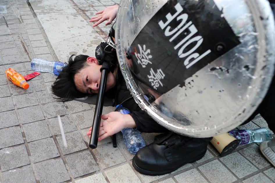 Police arrest a Hong Kong protester after a Chinese flag was removed from a flag pole at a Hong Kong rally in support of Xinjiang Uyghurs' human rights in Hong Kong, December 22, 2019. 