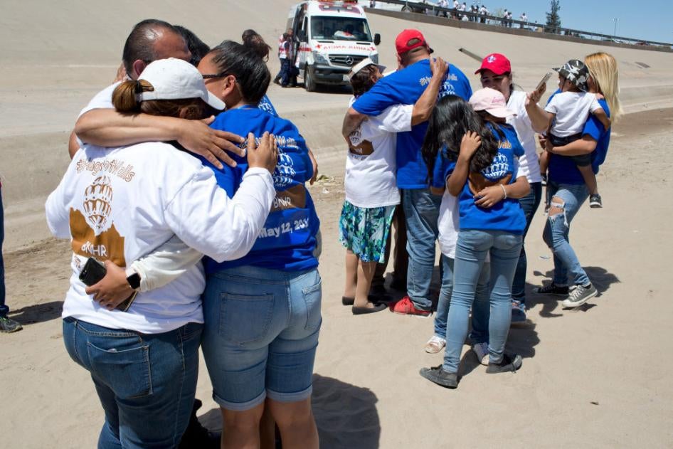 Immigrant families separated by immigration status, lack of visas, or deportations, are briefly reunited in the dry Rio Grande riverbed 
