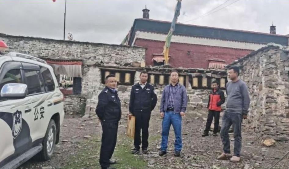 Flanqué de deux policiers, Zhang Ling, directeur du Bureau de la sécurité publique du comté de Tingri au Tibet (au centre de la photo) a mené une « visite d'inspection » au monastère de Tengdro près du village de Shekar, le 2 juillet 2020.