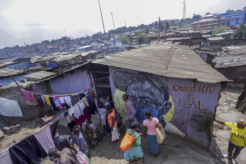 Des membres d'une organisation kenyane distribuent des masques faciaux et de la nourriture a des familles vivant à Mathare, un bidonville dans la banlieue de Nairobi dont les habitants sont particulièrement touchés sur le plan économique par la pandémie de Covid-19.