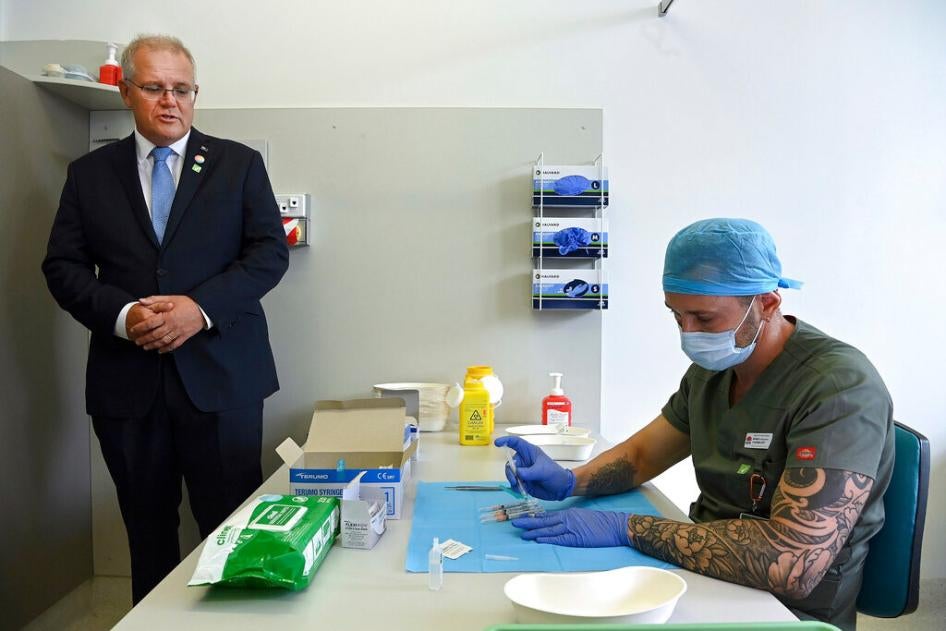 Australian Prime Minister Scott Morrison, left, watches a pharmacist prepare a simulated vaccine at the Sydney local health district vaccination hub in Sydney, February 19, 2021.