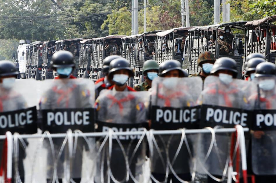 Une rangée de policiers, soutenus par des militaires dans des véhicules, étaient déployés devant une barrière routière à Mandalay, au Myanmar, le 19 février 2021.