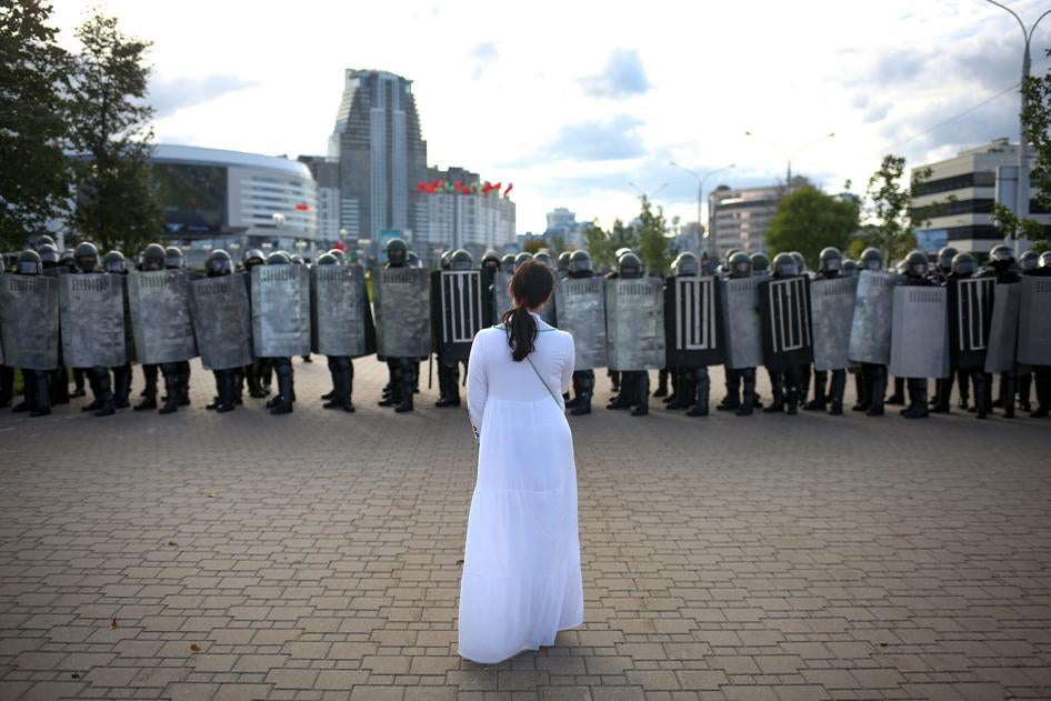 A woman wearing white stands in front of riot police during a Belarusian opposition rally protesting the official presidential election results in Minsk, Belarus, September 13, 2020. 