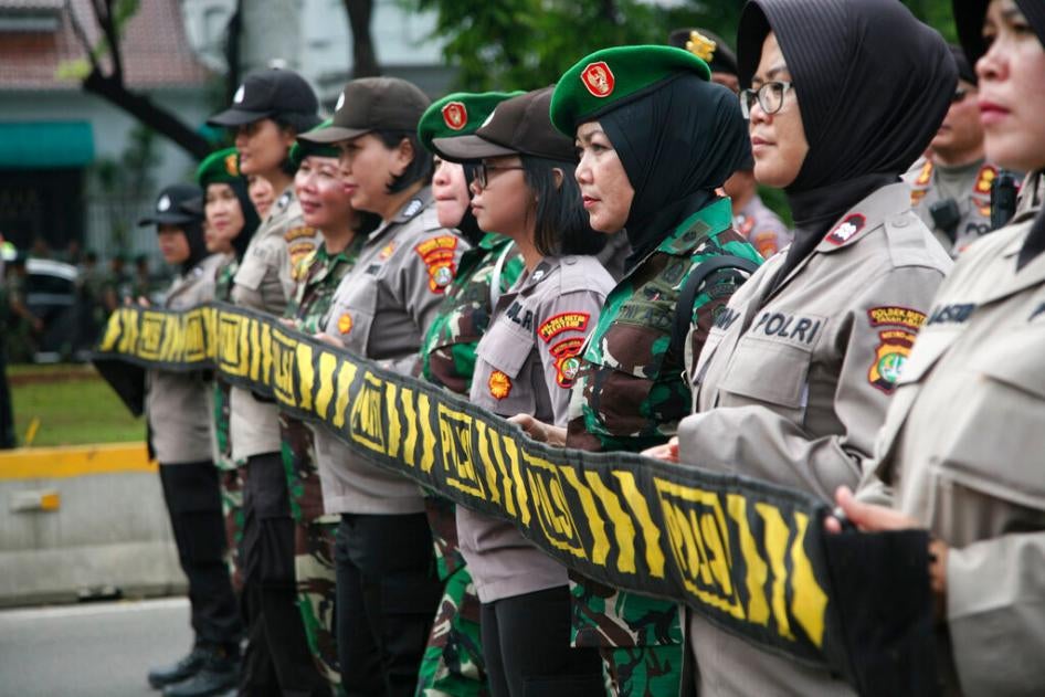 Sejumlah anggota Polwan dan Kowad mengawal ratusan perempuan yang memadati area di depan Istana Negara di Jakarta, pada 8 Maret 2020, dalam peringatan Hari Perempuan Internasional. 