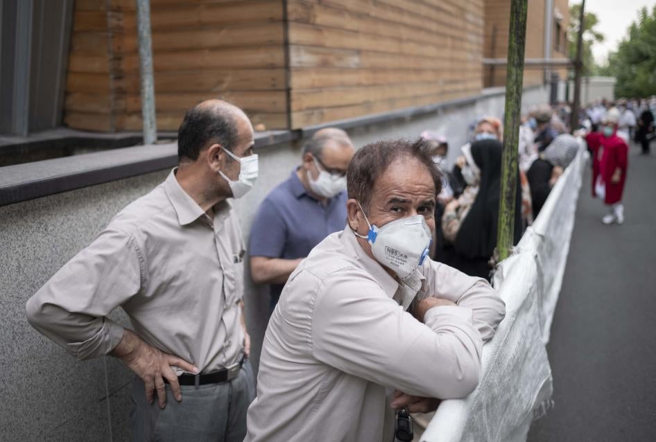 یک مرد ایرانی با ماسک در صف واکسن برای دریافت واکسن چینی سینوفارم  در مرکز تهران در تاریخ ۱۹ ژوییه ۲۰۲۱ ایستاده است. 