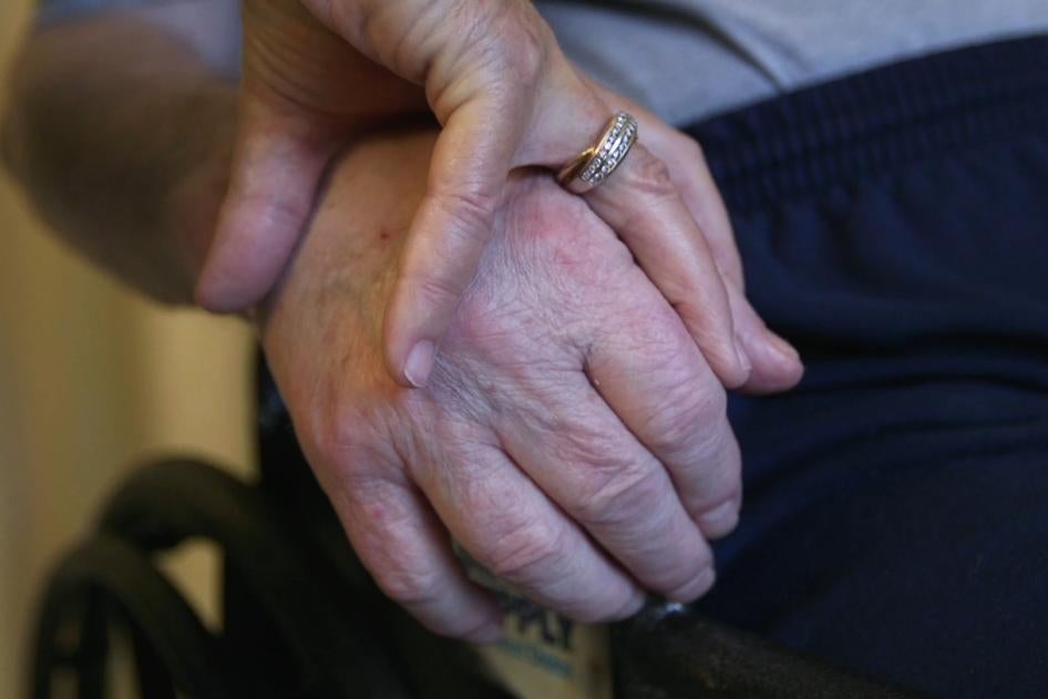 A nursing home resident holds his wife’s hand.  © Human Rights Watch.