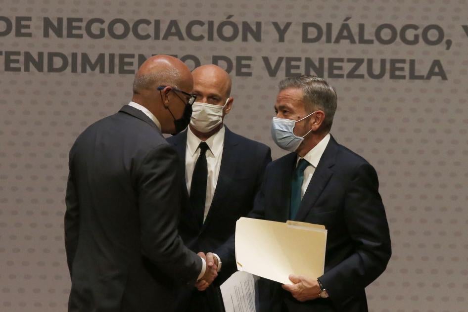 Jorge Rodriguez, left, representing the Maduro government, shakes hands with Venezuelan opposition delegate Gerardo Blyde Perez, in Mexico City, Friday, Aug. 13, 2021.