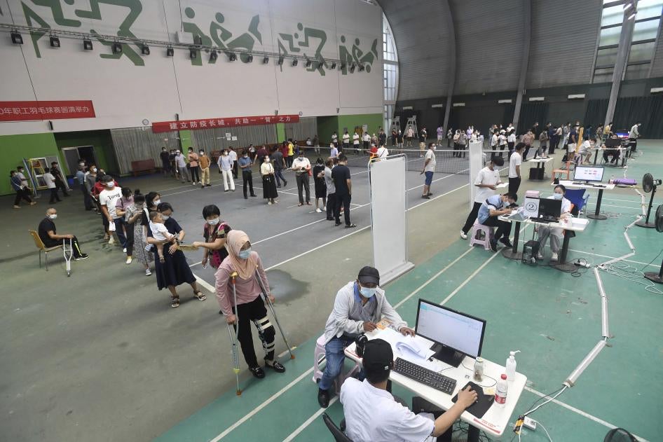 中國中部湖北省武漢市一處臨時注射站，移住勞工和市民正在排隊接種新冠肺炎疫苗，2021年8月23日。