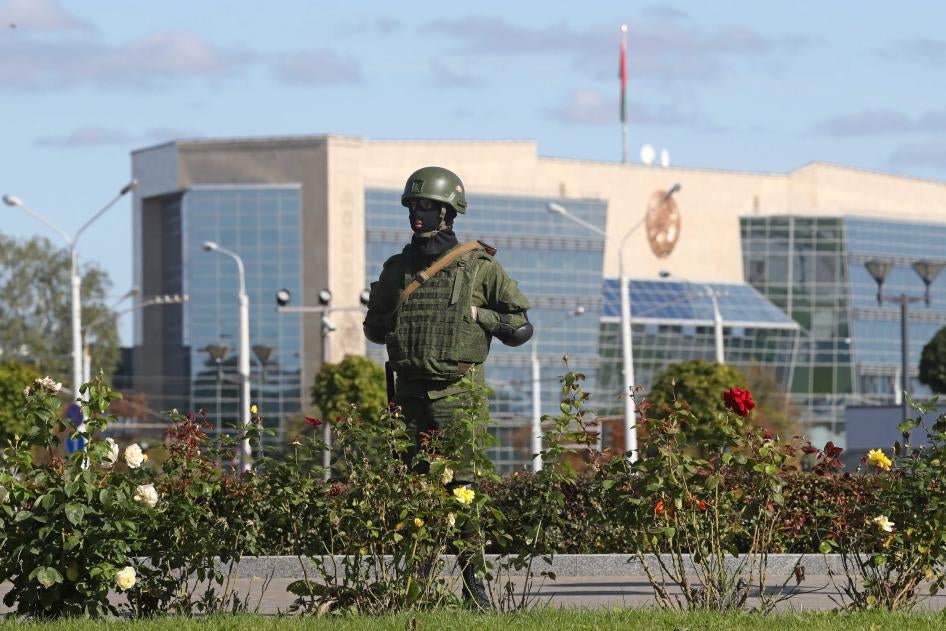 A riot police officer guards the area in State Flag Square, Minsk, Belarus, with the Supreme Court building in the background.