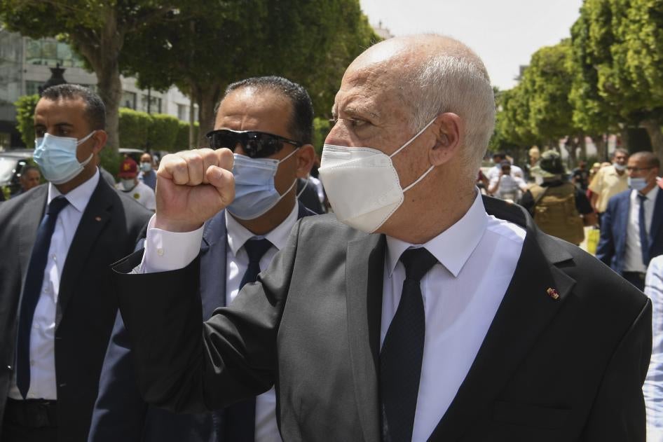 Tunisian President Kais Saied raises his fist to bystanders as he walks along the avenue Bourguiba in Tunis, Tunisia, August 1, 2021.