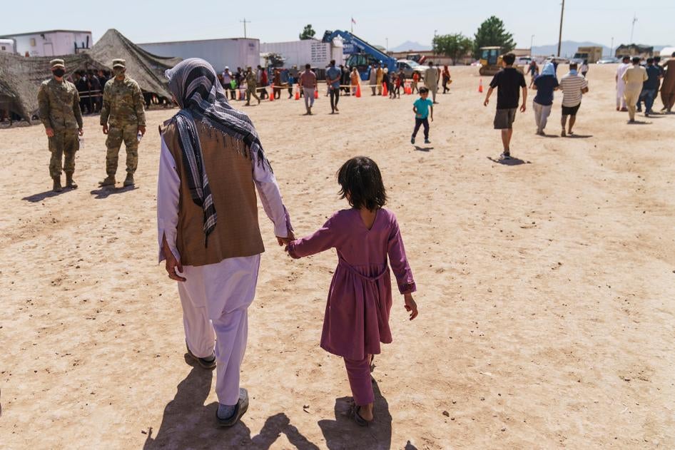A man walks with a child through Doña Ana Village in Fort Bliss, where Afghan refugees are being housed, in New Mexico on September 10, 2021.