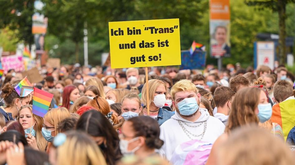 A demonstrator on a march in Oldenburg, Germany, on Christopher Street Day 2021, holds a sign with the inscription “I am ‘Trans’ and that's good!” September 21, 2021. © 2021 Mohssen Assanimoghaddam/picture-alliance/dpa/AP Images