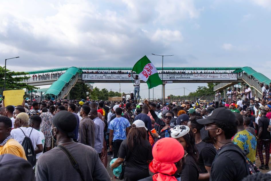 An #EndSARS protester raises a Nigerian flag on the Lagos-Ibadan Expressway in Lagos, Nigeria on October 15, 2020.
