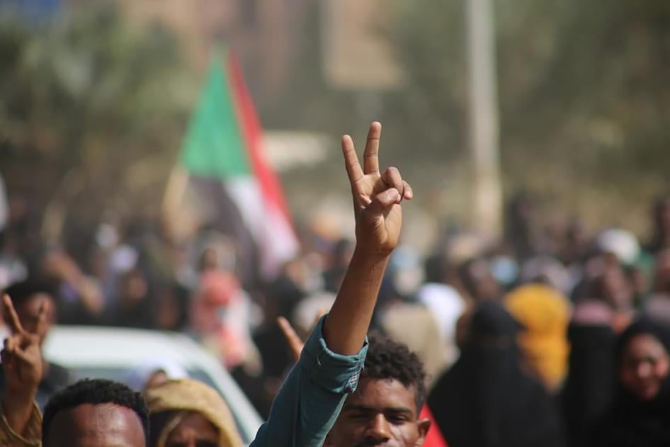 متظاهرون مؤيدون للديمقراطية يرفعون إشارة النصر بعدما نزلوا إلى الطرقات لإدانة استيلاء ضباط الجيش على السلطة، في الخرطوم، في 25 أكتوبر/تشرين الأول 2021.