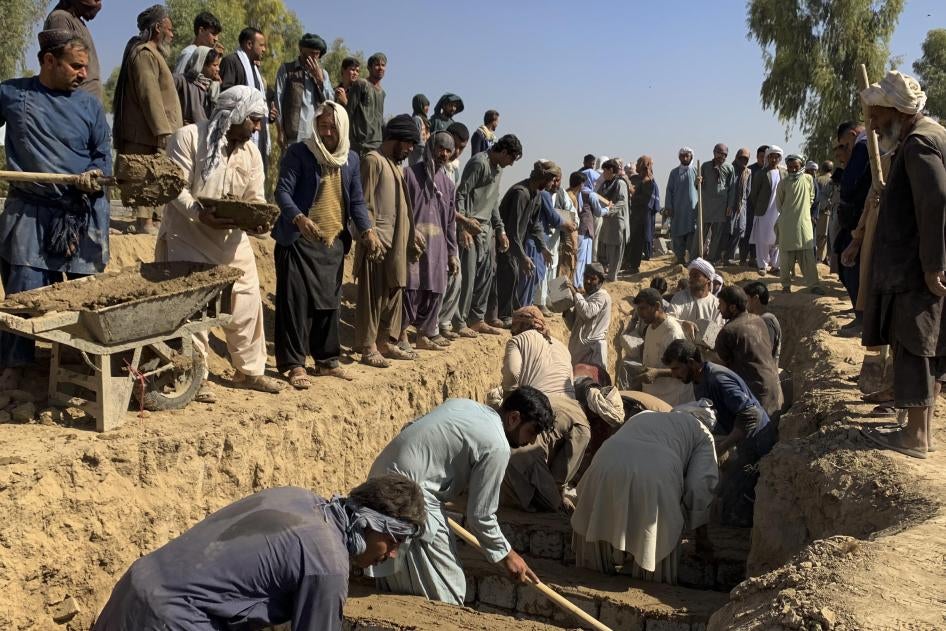 Des proches de victimes et des résidents locaux de Kandahar, en Afghanistan, creusaient une fosse commune le 16 octobre 2021.