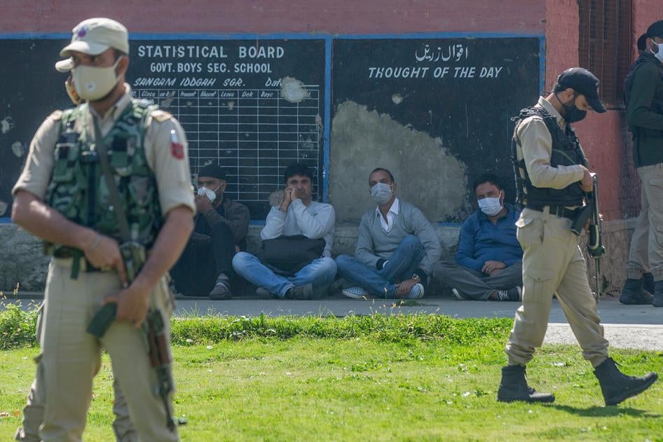 Indian paramilitary soldiers stand guard next to teachers at a government school where suspected militants fatally shot two teachers on the outskirts of Srinagar, India, October 7, 2021. 