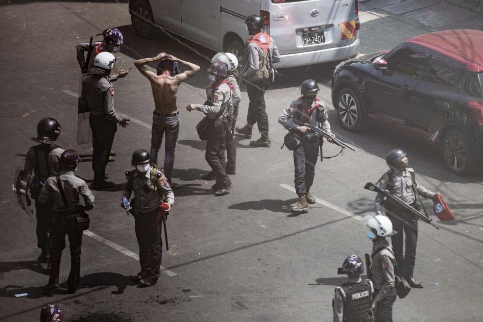 Aerial image of uniformed police officers detaining a protester 