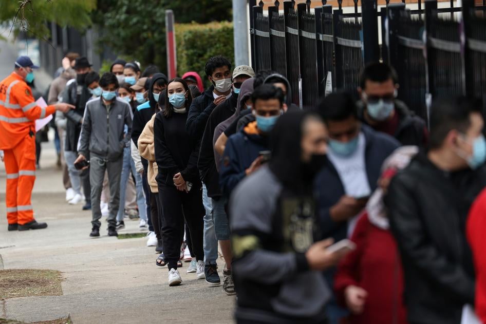 People wait outside a Covid-19 vaccination clinic in the Bankstown suburb during a lockdown in Sydney, Australia, August 25, 2021.