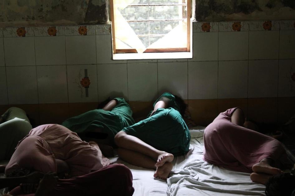 Women lying on the ground in a room.