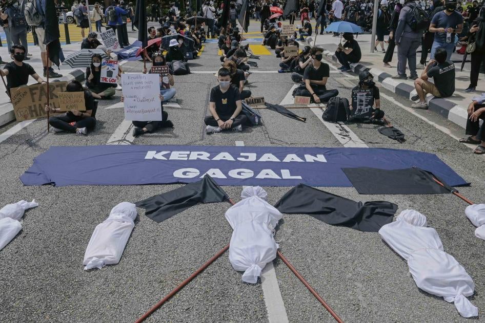 Golongan muda Malaysia protes duduk di samping kain rentang yang tercatat “Kerajaan Gagal” sekali gus menuntut peletakan jawatan Perdana Menteri Muhyiddin Yassin atas dakwaan salah urus Covid-19, Kuala Lumpur, 31 Julai 2021.