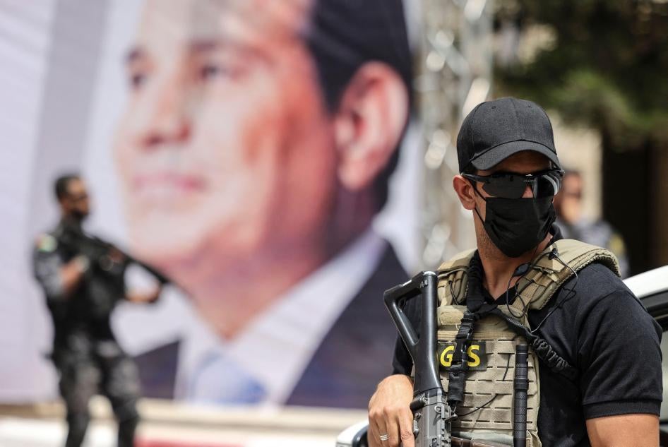 Ein Mitglied des ägyptischen Geheimdienstes hält Wache neben einem Banner, das Präsident Abdel Fattah al-Sisi zeigt.
