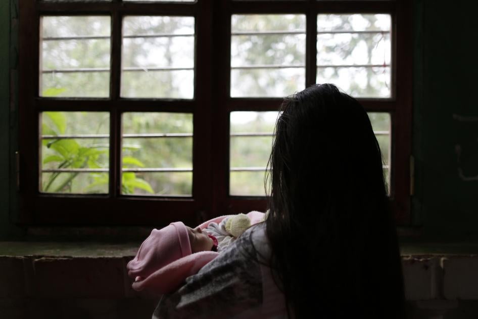 Una niña de 13 años víctima de violación en un caso distinto sostiene a su bebé de un mes en un albergue en Ciudad del Este, Paraguay, el 14 de mayo de 2015.